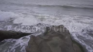 破浪后，一股灰色海水涌进海滩和海岸.