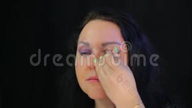 一个女人用一抹深紫色的阴影遮住她的眼睛