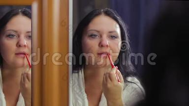 一个穿着白大褂的年轻女子在镜子前用一支红铅笔把嘴唇的轮廓包围起来