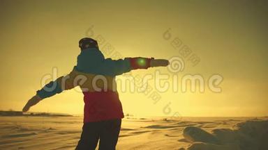 一个女孩站在雪山生活方式之上的剪影，一个梦想和旅行的概念。 她梦想着