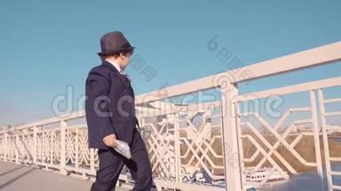 穿着黑色西装戴帽子从桥上<strong>扔钱</strong>的小商人。 浪费金<strong>钱</strong>