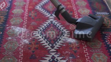 家庭主妇用吸尘器清理厨房地毯上的谷物，动作缓慢