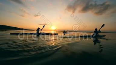 运动员们正在划独木舟穿过日落湖