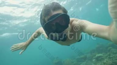 年轻人带着浮潜和面具在海上浮潜，拍摄自拍<strong>视频</strong>。 在珊瑚礁和<strong>海底</strong>游泳的人