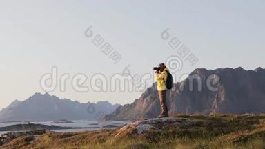一位女士用数码单反相机从山上拍摄挪威风景