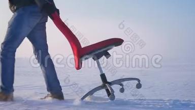 多利宽的运动员穿着温暖的外套和引擎盖，慢慢地拉着<strong>一把</strong>红色的<strong>椅子</strong>沿着雪场。