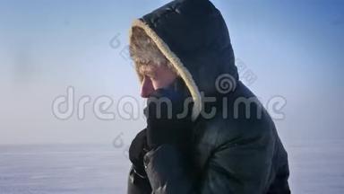 在雪地沙漠里用手机<strong>忙着</strong>说话的冷冻商人的特写照片。