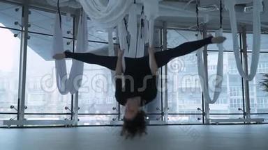 美丽的女人，有着迷人的身体，在吊床上做反重力空中瑜伽，在吊床上做反重力瑜伽运动