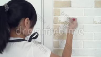 在公寓或房子里用刷砖<strong>墙画</strong>的女人的特写。
