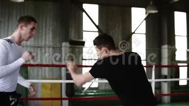 穿着便服的拳击台上的年轻拳击手互相拳打脚踢。 男人训练，火车罢工和反应。 老了
