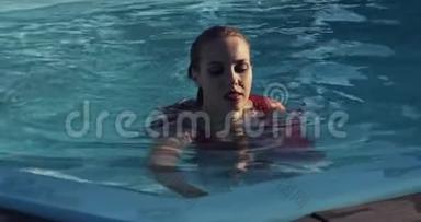 女人正在游泳池里游泳。 穿着红色长裙，4K