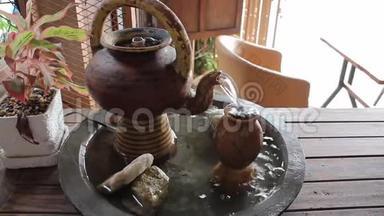 一只泥制茶壶，桌上有水
