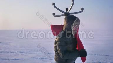 穿着温暖外套和引擎盖的运动员在雪地背景<strong>上</strong>绕着他肩膀<strong>上</strong>的一把红色椅子<strong>走来走去</strong>。