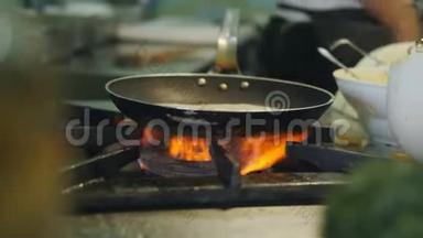 厨师在一家户外餐馆用高<strong>热量</strong>在煎锅里用蘑菇准备意大利面。