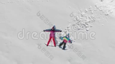 年轻的母亲和小女儿在雪地上做天使。 阳光明媚的冬日，欢乐的家庭尽情欢乐