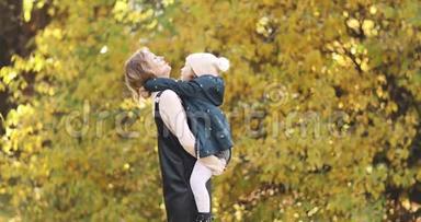 <strong>妈妈</strong>把女儿抱在<strong>怀里</strong>，在花园里接吻。