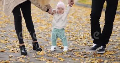 快乐的宝宝在秋天的公园里学习走路。