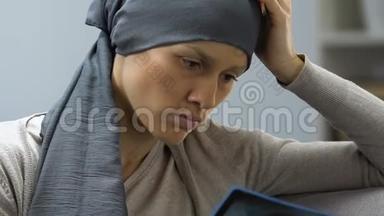 患有癌症的悲伤女人看着x光图像，气馁，没有奋斗的意志