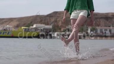 瘦小的女孩子`沙滩上慢动作地玩水.
