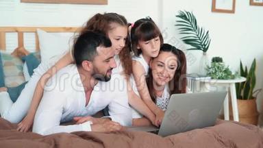 爸爸，妈妈和两个女儿在笔记本<strong>电脑</strong>上<strong>玩电脑</strong>游戏，慢动作