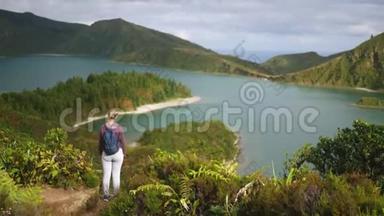 一位年轻的女游客站在一个俯瞰<strong>大海</strong>的<strong>高山</strong>湖附近