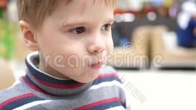 一个男孩在一家快餐店喝碳酸的甜饮料通过管子。 嘴巴紧闭
