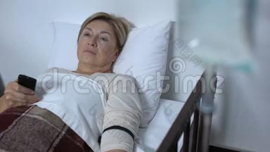 虚弱的老年妇女病人在医院病房看电视，在病床上睡着