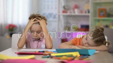 累了的孩子坐在书桌前睡着了，课后教育累坏了