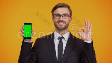 商务男士展示智能手机，绿色屏幕和OK手势，<strong>现金返</strong>还