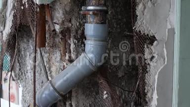 正在修理的房子里的旧下水道。 破墙里的水管