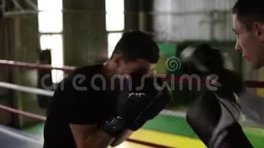 身穿便服的年轻男拳击手在拳击台上互相拳打脚踢。 男子训练，火车打击，保护