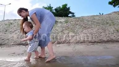 一个小男孩和他的母亲在沙滩附近的<strong>水中玩耍</strong>