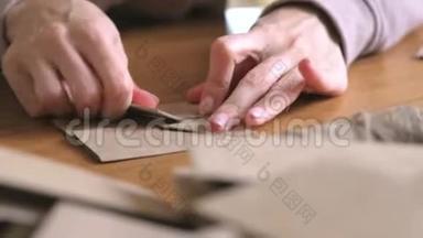 女人用牛皮纸做纸袋。 双手特写.. 弯曲尺子。