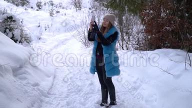 女孩在一个下雪的冬天<strong>森林</strong>里拍摄<strong>视频</strong>。 她`高兴。 一个女孩正在智能手机上录制<strong>视频</strong>。 慢动作。