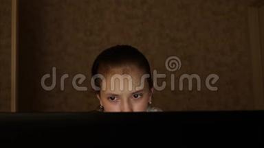 那个女孩在电脑上玩。 一个年轻的女人正在用笔记本电脑工作。 一个疲惫的女学生在家里用笔记本电脑工作