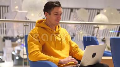 年轻人在一家现代化的大咖啡馆里手提电脑