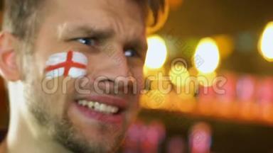 英国足球迷，脸上挂着<strong>旗子</strong>，为最喜欢的球队输球而苦恼