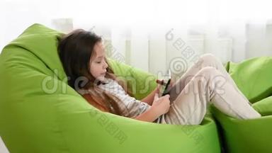 小女孩坐在椅子上用笔记本电脑快乐的乐趣。 关闭技术玩家。 慢动作。 胜利者欢乐的情绪