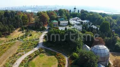 基辅植物园在夏季从高处。 人们带着花坛在公园里散步，一群鸟飞过