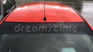 <strong>雨滴</strong>和<strong>雨滴</strong>滴在停着的红色客车的挡风玻璃和车顶上。 秋天多雨的天气。 特写