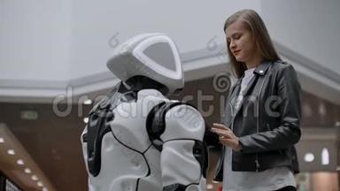 与机器人接触的快乐女人。 点击机器人屏幕.. 机器人和女人互动。