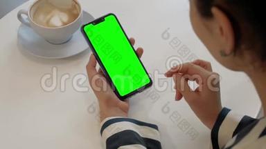 一个女人正在和一个朋友通过绿色屏幕智能手机的视频通话