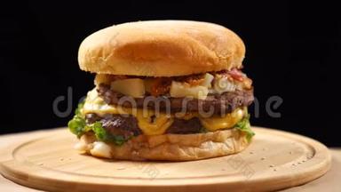 汉堡，有牛肉，奶酪和蔬菜在<strong>木板</strong>上旋转。 <strong>黑色背景</strong>
