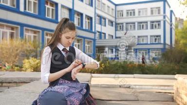 在学院的院子里休息的少女拿着一个背包坐在女儿墙上，并把闹钟按在上面