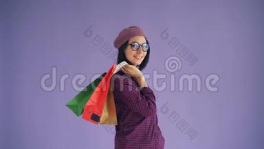 戴着眼镜、戴着时尚帽子、手提购物袋的幸福年轻女士画像