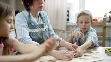 妈妈一边给孩子们讲故事，一边铺床单，一边在厨房的桌子上擀面包做饼干