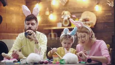 幸福的家庭正在为复活节<strong>做准备</strong>。 可爱的小男孩戴着兔子耳朵。 春日快乐。 复活节彩蛋