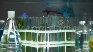 研究人员用测试液体检查管子中的沉积物，维生素的产生