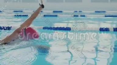 特写镜头。 熟练的女游泳运动员在游泳池里训练。 她<strong>爬行</strong>或<strong>爬行</strong>，用手划。 她是