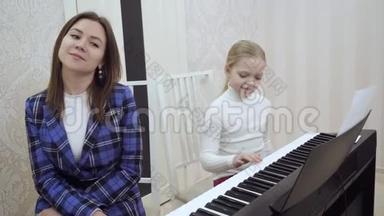 小可爱的女孩检查耳朵听她的老师的音乐。